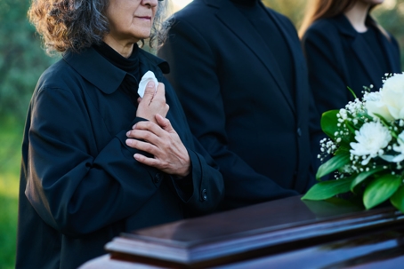 Close-up of mourning mature woman in black attire.